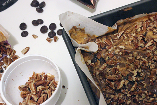 Topping Ghirardelli Chocolate Pumpkin Brownies with Chopped Pecans